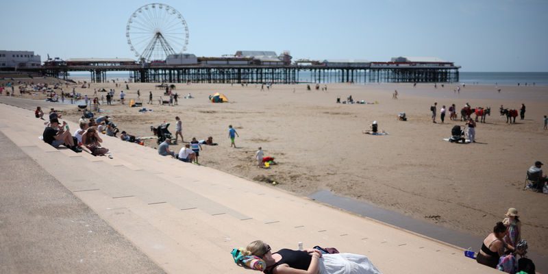 epaselect epa12997821 A person lies on the promenade steps at the seaside resort of Blackpool, Britain, 27 May 2026. The UK is experiencing a record-breaking heatwave, with temperatures exceeding 35 degrees Celsius, marking the hottest May on record.  EPA/ADAM VAUGHAN