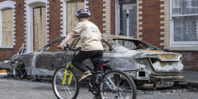 epa13028251 A burnt-out car is seen on McMaster Street  following riots in Belfast, Northern Ireland, 10 June 2026. The Police Service of Northern Ireland (PSNI) said there was a night of unrest across Northern Ireland on 9 June, with incidents reported in several towns and cities including greater Belfast. The violence came after the attempted murder of a man in the Kinnaird Avenue area of north Belfast, who remains in hospital with serious injuries. Three people have been arrested so far in Belfast following the unrest.  EPA/ANDREAS BECKER EDITORIAL USE ONLY