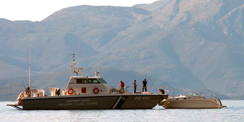 Coast guard officers tie a boat to their vessel near the coast of Lefkada island in the Ionian Sea, western Greece, Friday, Nov. 15, 2013. Twelve migrants, believed to be Syrians, were found dead after the boat still tied to rocks capsized in calm weather, authorities said. Another 15 people survived the incident that occurred near the island of Lefkada as coast guard divers recovered the bodies of four children and eight adults after survivors alerted authorities, the Merchant Marine Ministry said. (AP Photo/Dimitris Dimitriou)